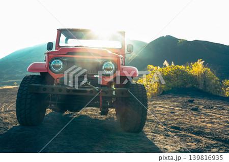 Classic jeep drives on volcanic terrain under the sun in Bali Classic jeep drives on volcanic terrain under the sun in Bali 139816935