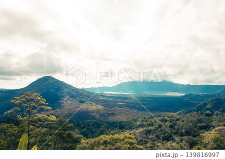 View of mountains and a lake surrounded by trees in Bali View of mountains and a lake surrounded by trees in Bali 139816997