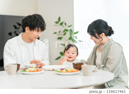 食卓で赤ちゃんに離乳食,ご飯を食べさせる母親と父親（育児・子育て） 139817461