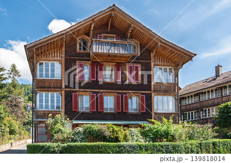 Traditional Swiss Chalet Facade with Red Shutters in Switzerland, Europe on Sunny Day Traditional Swiss Chalet Facade with Red Shutters in Switzerland, Europe on Sunny Day 139818014