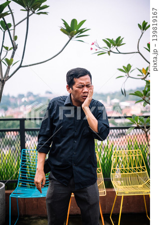 Adult man suffering from painful toothache or severe face pain outdoors 139819167
