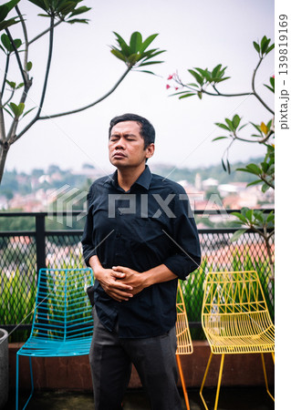 Man Suffering from Abdominal Pain on Outdoor Balcony 139819169