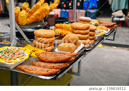 An abundance of traditional Vietnamese street food snacks including corn dogs donuts and banh mi are displayed at a market stall in Hoi An Vietnam An abundance of traditional Vietnamese street food snacks including corn dogs donuts and banh mi are displayed at a market stall in Hoi An Vietnam 139819312