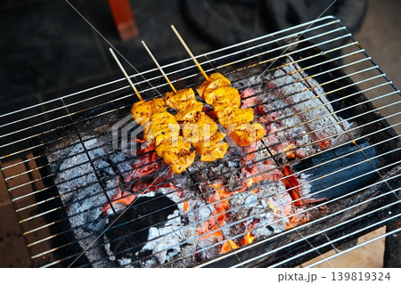 Traditional Vietnamese Thit Nuong meat skewers are grilled over hot burning charcoal at a street food market stall in Hoi An ancient town Traditional Vietnamese Thit Nuong meat skewers are grilled over hot burning charcoal at a street food market stall in Hoi An ancient town 139819324