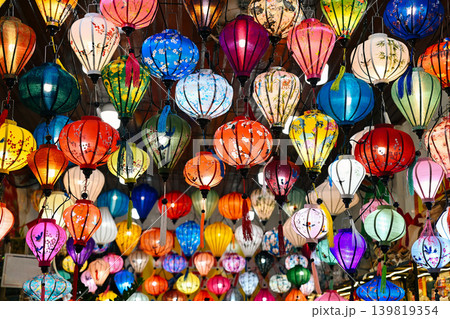 Abundance of traditional colorful Hoi An silk lanterns with diverse bright patterns hanging in rows at night souvenir street market in Hoi An Vietnam Abundance of traditional colorful Hoi An silk lanterns with diverse bright patterns hanging in rows at night souvenir street market in Hoi An Vietnam 139819354