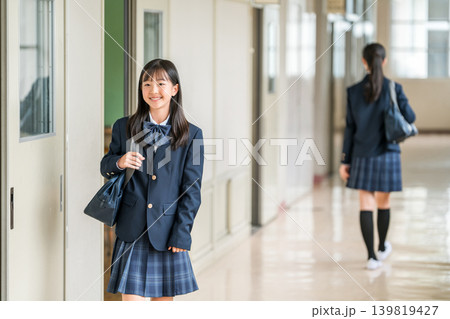 学校の廊下を歩く制服姿の小学生,中学生,高校生の女子生徒 139819427