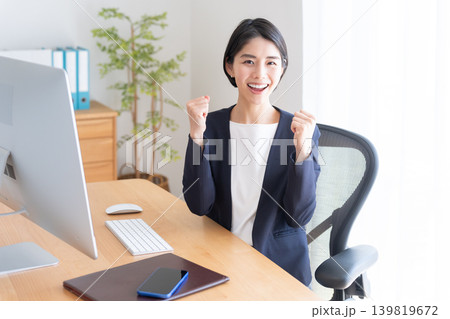 デスクトップパソコンで仕事するビジネスウーマン（ガッツポーズ） 139819672