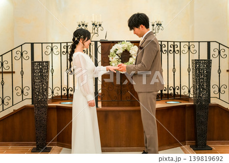 結婚式場で指輪交換する新郎新婦(結婚式,ウェディング,ブライダル) 結婚式場で指輪交換する新郎新婦(結婚式,ウェディング,ブライダル) 139819692