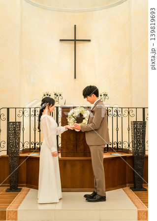 結婚式場で指輪交換する新郎新婦(結婚式,ウェディング,ブライダル) 結婚式場で指輪交換する新郎新婦(結婚式,ウェディング,ブライダル) 139819693