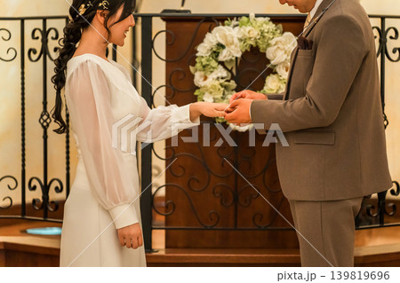 結婚式場で指輪交換する新郎新婦(結婚式,ウェディング,ブライダル) 結婚式場で指輪交換する新郎新婦(結婚式,ウェディング,ブライダル) 139819696