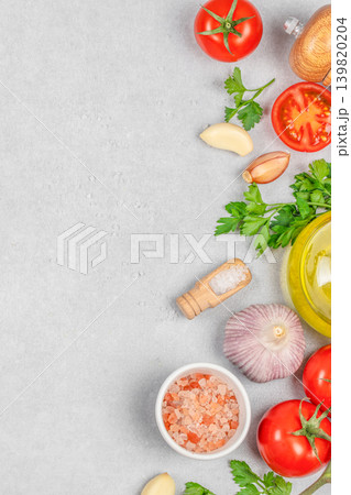 Tomatoes garlic parsley and olive oil on gray background top view Tomatoes garlic parsley and olive oil on gray background top view 139820204