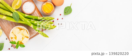 Fresh asparagus ingredients with butter eggs and spices on white background, top view copy space Fresh asparagus ingredients with butter eggs and spices on white background, top view copy space 139820220