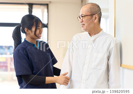 笑顔で会話をするシニアと外国人介護士 笑顔で会話をするシニアと外国人介護士 139820595