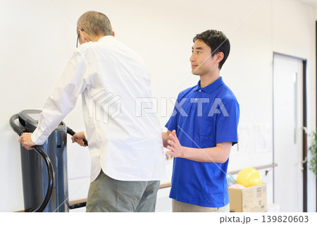振動トレーニングマシンでリハビリをするシニアと介護士 139820603