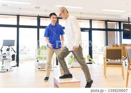踏み台でリハビリをするシニアと介護士 踏み台でリハビリをするシニアと介護士 139820607
