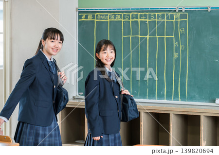 笑顔で会話しながら教室に入ってくる制服姿の小学生,中学生,高校生の女の子 笑顔で会話しながら教室に入ってくる制服姿の小学生,中学生,高校生の女の子 139820694