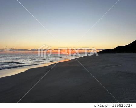 沈みゆく夕日と穏やかな砂浜の風景 139820727