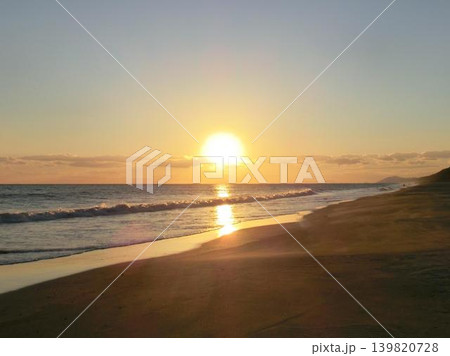 波間に反射する夕日と穏やかな砂浜の風景 139820728