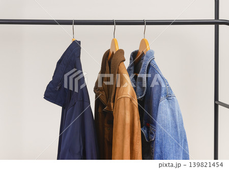 Different men jackets hanging on clothing rack. Garments include leather textile and denim pieces. Menswear outerwear assortment for casual wardrobe.. Different men jackets hanging on clothing rack. Garments include leather textile and denim pieces. Menswear outerwear assortment for casual wardrobe.. 139821454