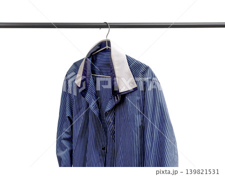 Striped shirt hanging on hanger below rail. Apparel garment suspended on rack. Male wardrobe clothing selection concept.. Striped shirt hanging on hanger below rail. Apparel garment suspended on rack. Male wardrobe clothing selection concept.. 139821531