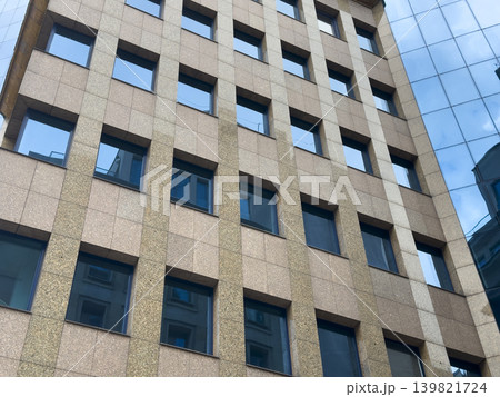 Modern building facade with blue window pattern and geometric symmetry. Abstract architectural Modern building facade with blue window pattern and geometric symmetry. Abstract architectural 139821724