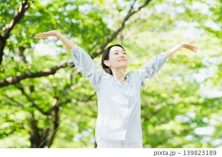 木の下でストレッチをする若い女性　ライフスタイルイメージ 139823189
