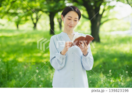 屋外で読書をする若い女性 ライフスタイルイメージ 屋外で読書をする若い女性 ライフスタイルイメージ 139823196