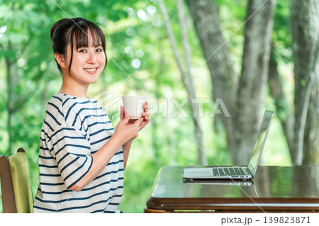 ワーケーション,滞在先で仕事をする一息つく,休憩する女性(お茶,飲む) ワーケーション,滞在先で仕事をする一息つく,休憩する女性(お茶,飲む) 139823871