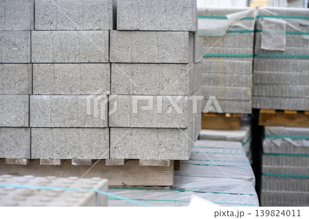 View of stacked gray paving slabs on a wooden pallet at a construction site View of stacked gray paving slabs on a wooden pallet at a construction site 139824011