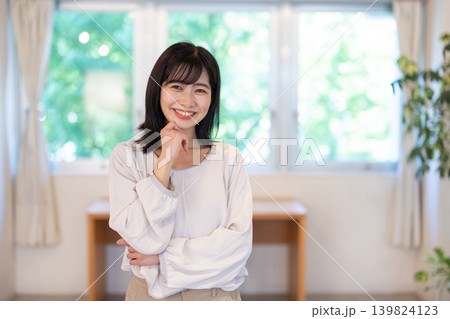 明るい室内でカメラ目線で微笑む日本人の若い女性 明るい室内でカメラ目線で微笑む日本人の若い女性 139824123
