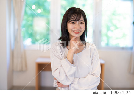 明るい室内でカメラ目線で微笑む日本人の若い女性 明るい室内でカメラ目線で微笑む日本人の若い女性 139824124
