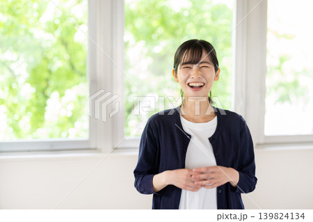 明るい室内でカメラ目線で微笑む日本人の若い女性 明るい室内でカメラ目線で微笑む日本人の若い女性 139824134