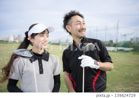 笑顔でゴルフレッスン(習う)女性イメージ ゴルフの先生と目標を見つめる、見上げる 笑顔でゴルフレッスン(習う)女性イメージ ゴルフの先生と目標を見つめる、見上げる 139824729
