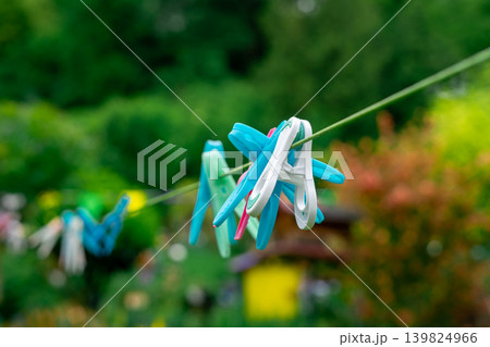 Multi-colored clothespins hang on a rope in the yard. Washing and drying clothes 139824966