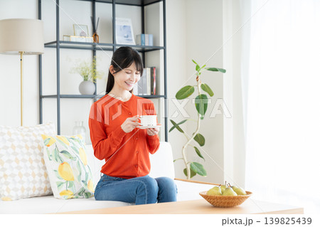 リビングでコーヒーを飲むミドルの女性 リビングでコーヒーを飲むミドルの女性 139825439