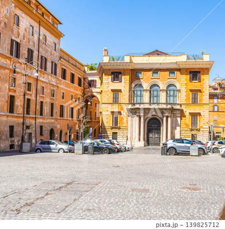 Sunny daytime view of an urban square in Rome, Italy, featuring old yellow orange palace facades, an architectural arch bridge street. Italian summer Sunny daytime view of an urban square in Rome, Italy, featuring old yellow orange palace facades, an architectural arch bridge street. Italian summer 139825712