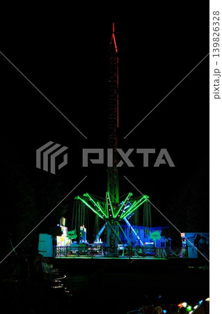 Tall illuminated swings ride at the County Fair operates at night 139826328