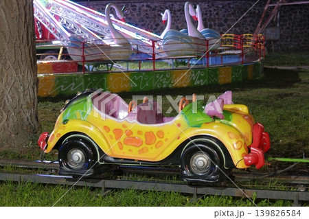 Two carnival rides are seen. The front is a car train Two carnival rides are seen. The front is a car train 139826584
