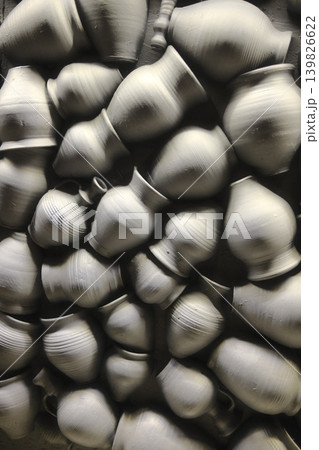 A collection of unfired clay pottery. They appear unfinished and are light grey A collection of unfired clay pottery. They appear unfinished and are light grey 139826622