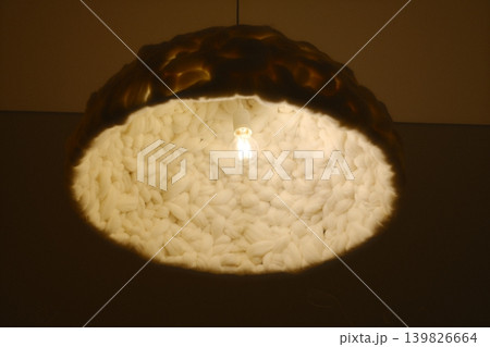A lamp hangs, casting upward light A lamp hangs, casting upward light 139826664