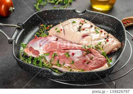 Duck meat in grill pan with herbs and pepper on dark background Duck meat in grill pan with herbs and pepper on dark background 139826797