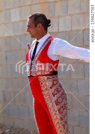 A long shot of a bullfighter preparing and stretching his muscles before the bullfight A long shot of a bullfighter preparing and stretching his muscles before the bullfight 139827563