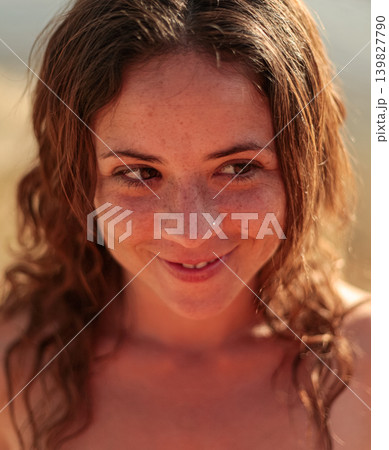 Smiling girl at sunset by a calm wetland landscape in warm evening light Smiling girl at sunset by a calm wetland landscape in warm evening light 139827790