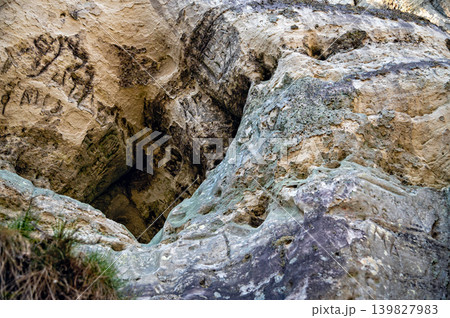 Sandstone rocks with carvings rise above the river trail in Gauja National Park Latvia. 139827983