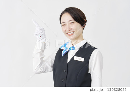 左側を指差す女性スタッフ 受付・バスガイド 白背景 左側を指差す女性スタッフ 受付・バスガイド 白背景 139828023