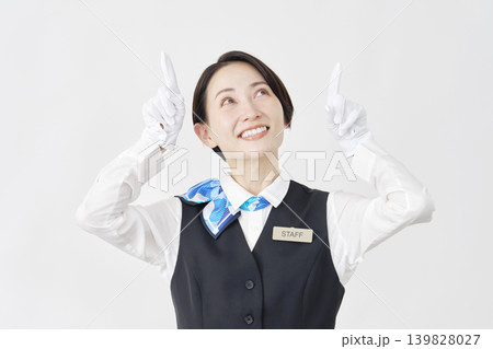 上を指差す女性スタッフ　受付・バスガイド　白背景 139828027