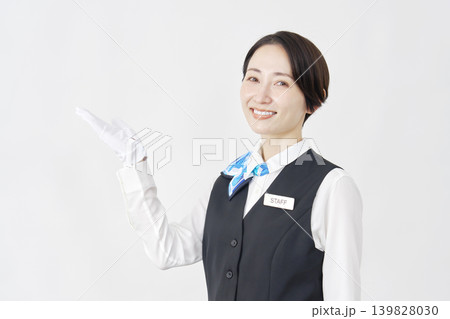 手のひらで左側を指す女性スタッフ 受付・バスガイド 白背景 手のひらで左側を指す女性スタッフ 受付・バスガイド 白背景 139828030