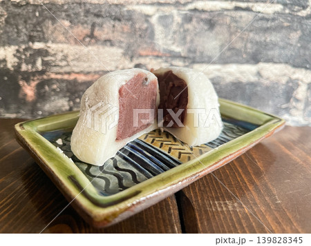 和菓子の塩豆大福の断面。ほんのりと塩味が効いた豆と餡子を大福餅で包んだ食べ物。 和菓子の塩豆大福の断面。ほんのりと塩味が効いた豆と餡子を大福餅で包んだ食べ物。 139828345