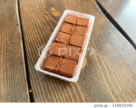 四角い生チョコレート。プラスチックの容器に入った、生クリームを混ぜた甘いチョコレート。 139828390