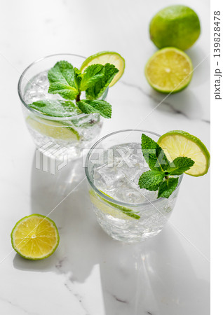 A fresh mojito with lime, mint and ice in glasses. Citrus lemonade or cocktail on a marble table 139828478